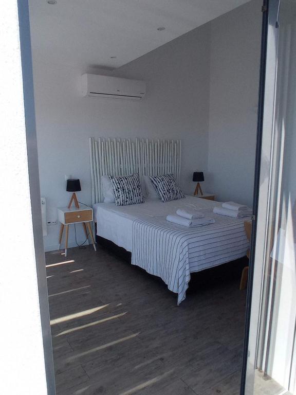 a bedroom with a bed and two lamps on tables at Flamingo Beach House in Santa Luzia