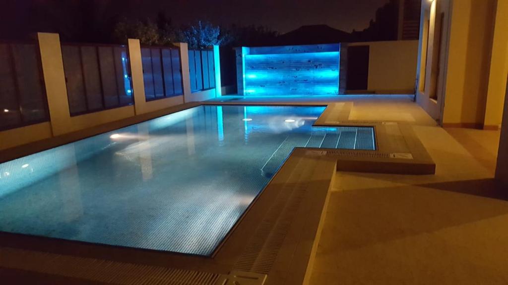 an empty swimming pool at night with blue lights at Royal Sea View Villa with Private Pool in Ras al Khaimah