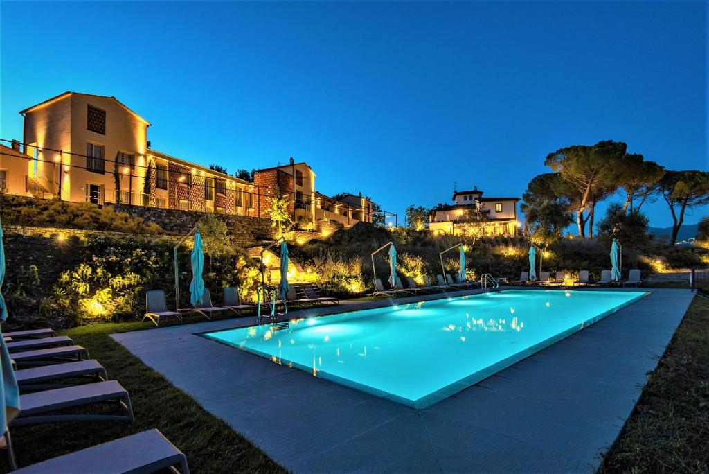 une piscine avec un complexe en arrière-plan dans l'établissement Resort 37, à Rignano sullʼArno