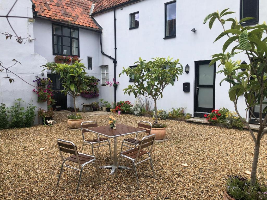 a patio with a table and chairs in front of a house at Church View Bungay in Bungay