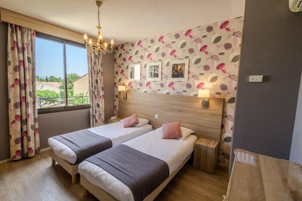 Postel nebo postele na pokoji v ubytování Hôtel l'Aragon