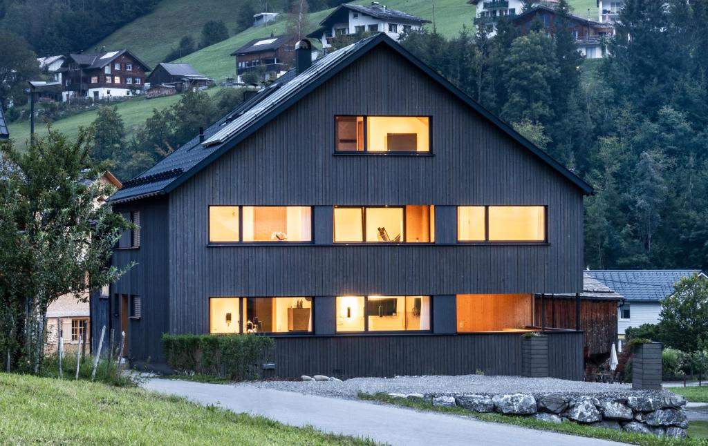 een zwart huis met een gambrel dak bij Haus Moosbrugger in Mellau