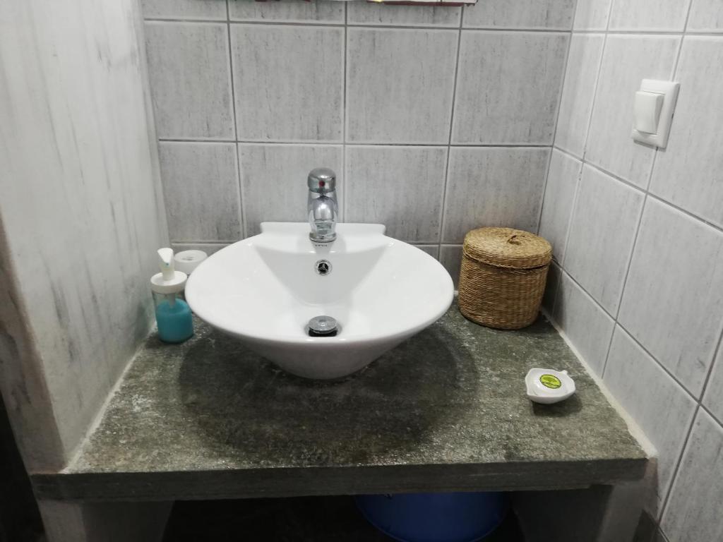 La salle de bains est pourvue d'un lavabo blanc sur un comptoir. dans l'établissement Madilides, à Platis Gialos