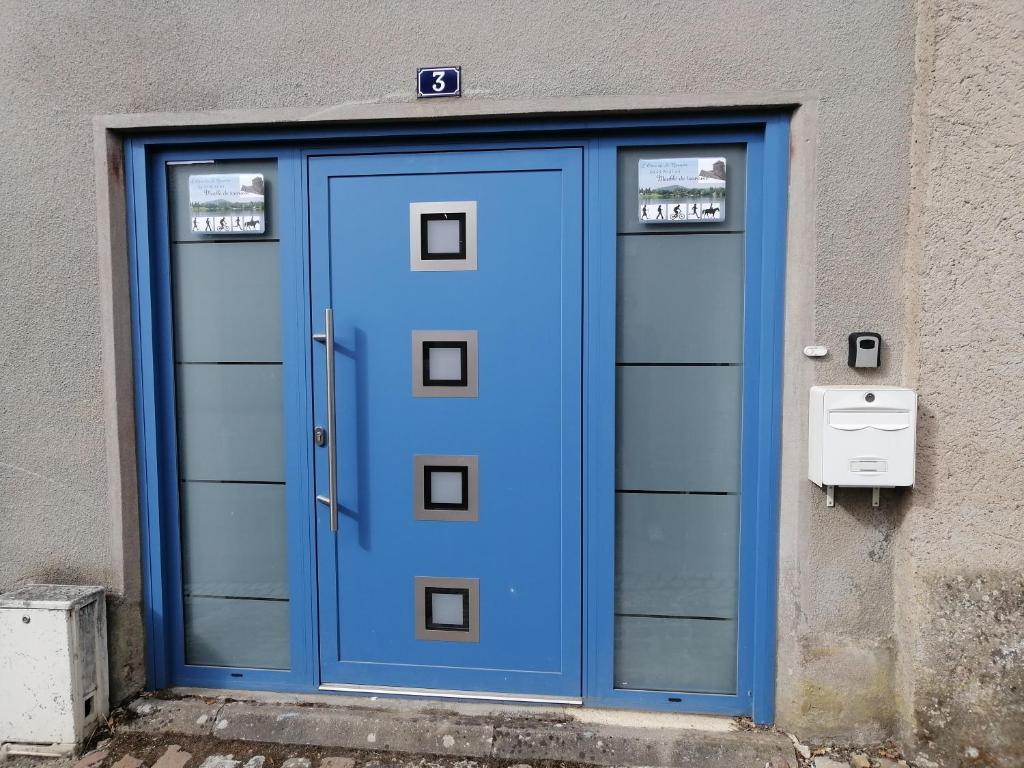 a blue door on the side of a building at L'orée du Saint Quentin in Lessy