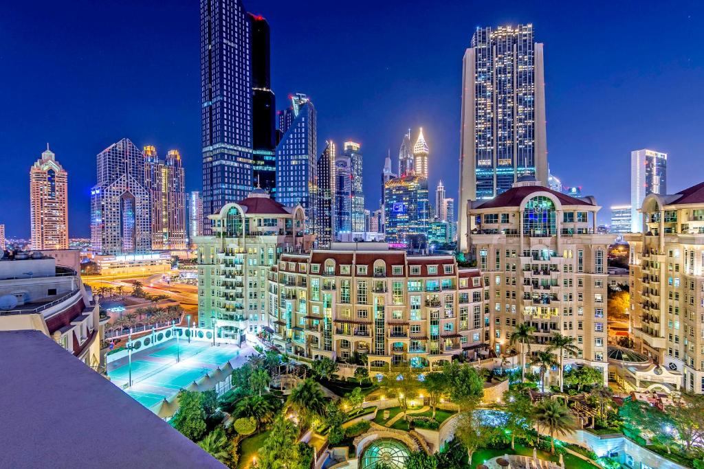 a city skyline at night with tall buildings at Roda Al Murooj Residences in Dubai