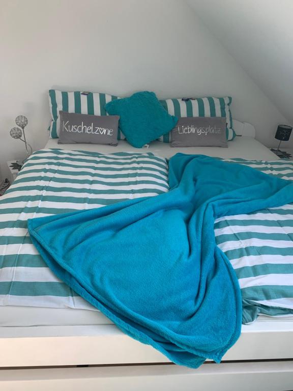 una coperta blu appoggiata sopra un letto di Mischa a Heide