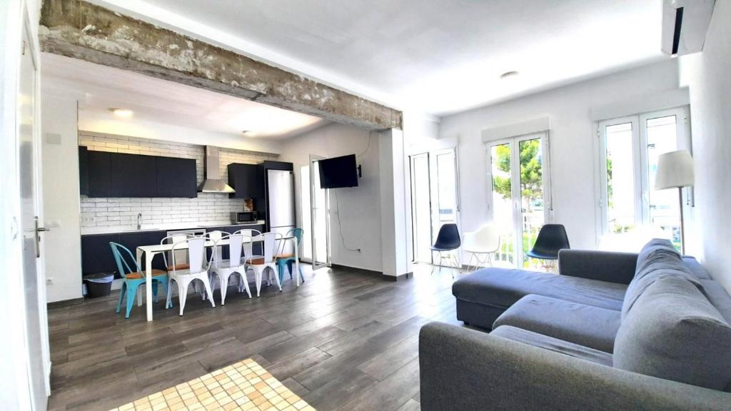 ein Wohnzimmer mit einem Sofa und einem Tisch in der Unterkunft Espectacular Apartamento con Vistas al Mar de 140m2 F5 1D in Gandía