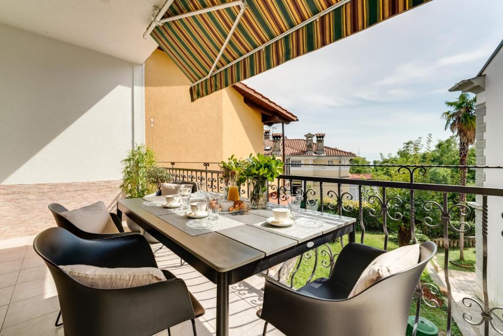 taras ze stołem i krzesłami na balkonie w obiekcie Luxury Apartment Regina w mieście Opatija