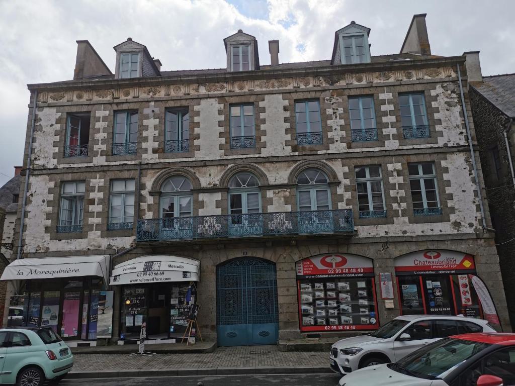 a large building with cars parked in front of it at Studio des Stuarts in Dol-de-Bretagne