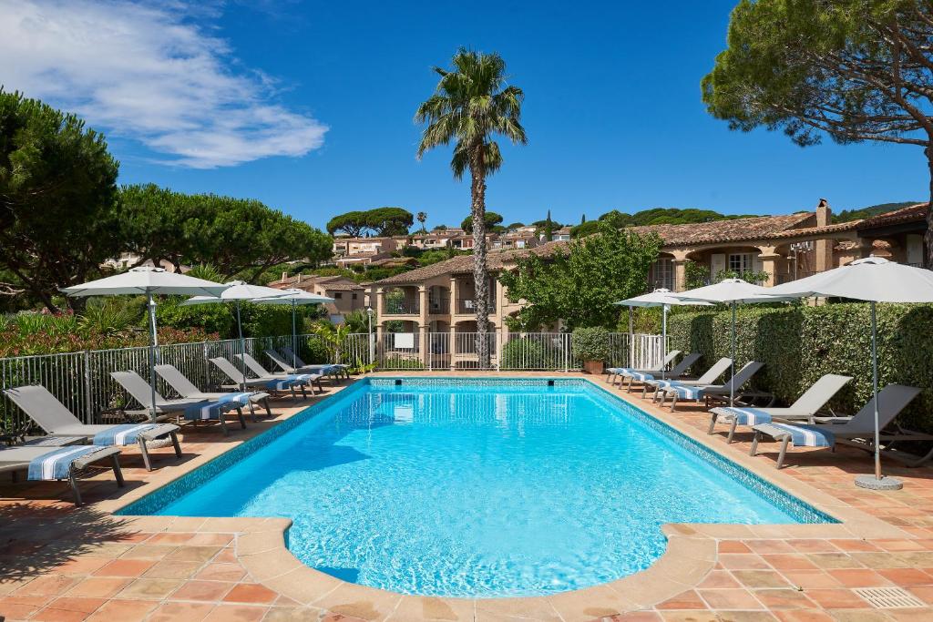 a beach with a pool, chairs, and a pool table at Domaine Du Calidianus in Sainte-Maxime