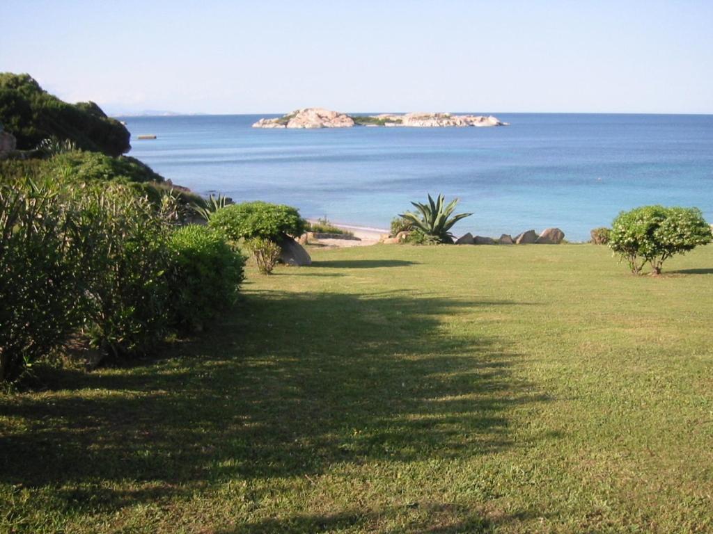 un campo de césped con vistas al océano en Villaggio la Marmorata, en Santa Teresa Gallura