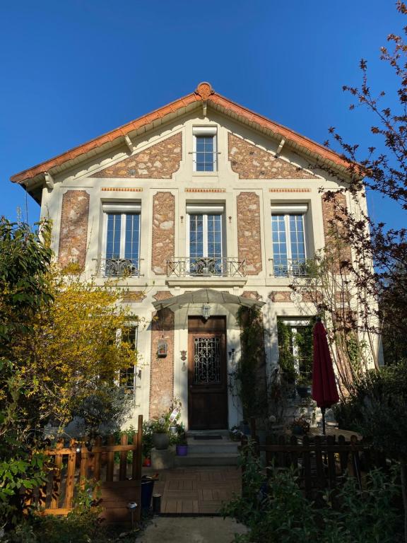 een groot bakstenen huis met een deur en ramen bij Maison du bonheur in Villiers-sur-Marne