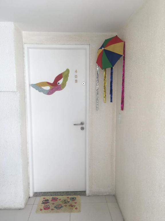 a white door with a kite hanging on the wall at Lindo Ap 403 Quadra do Mar c Garagem in Recife