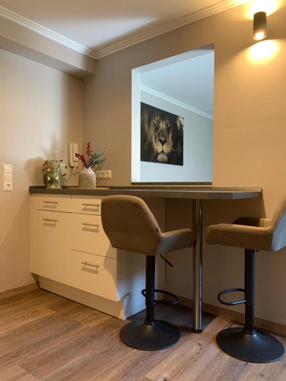 ein Büro mit einem Schreibtisch und 2 Stühlen in der Unterkunft African Suite - Maintal bei Frankfurt in Maintal