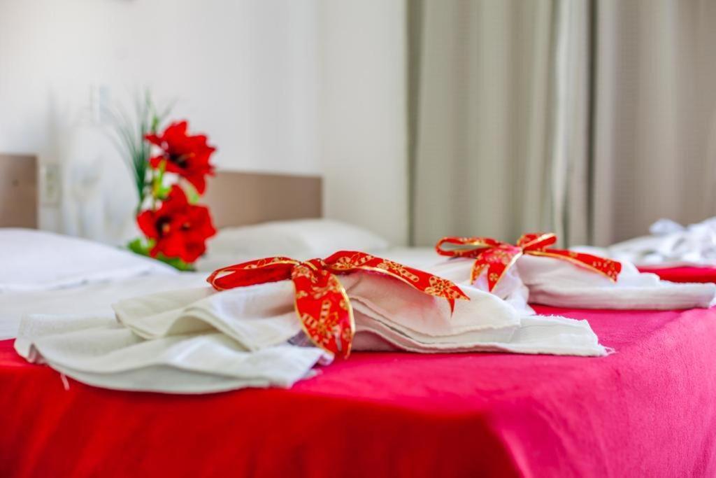 a group of white towels with red bows on a bed at Luxury Flats Ambiente Cristão in Fortaleza