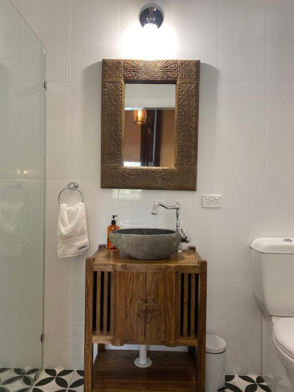 
a bathroom with a toilet, sink and mirror at Palmyra B&B in Rainbow Flat
