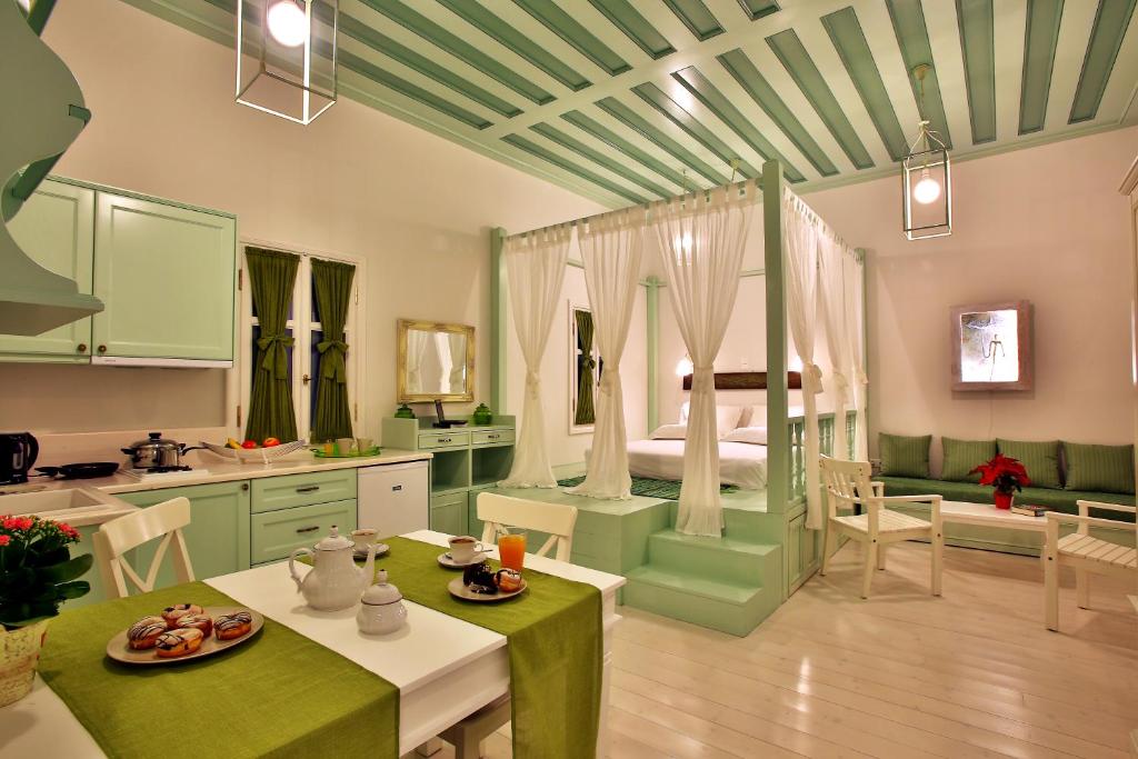 a kitchen with green cabinets and a room with a bed at Efchi 1904 in Rhodes Town