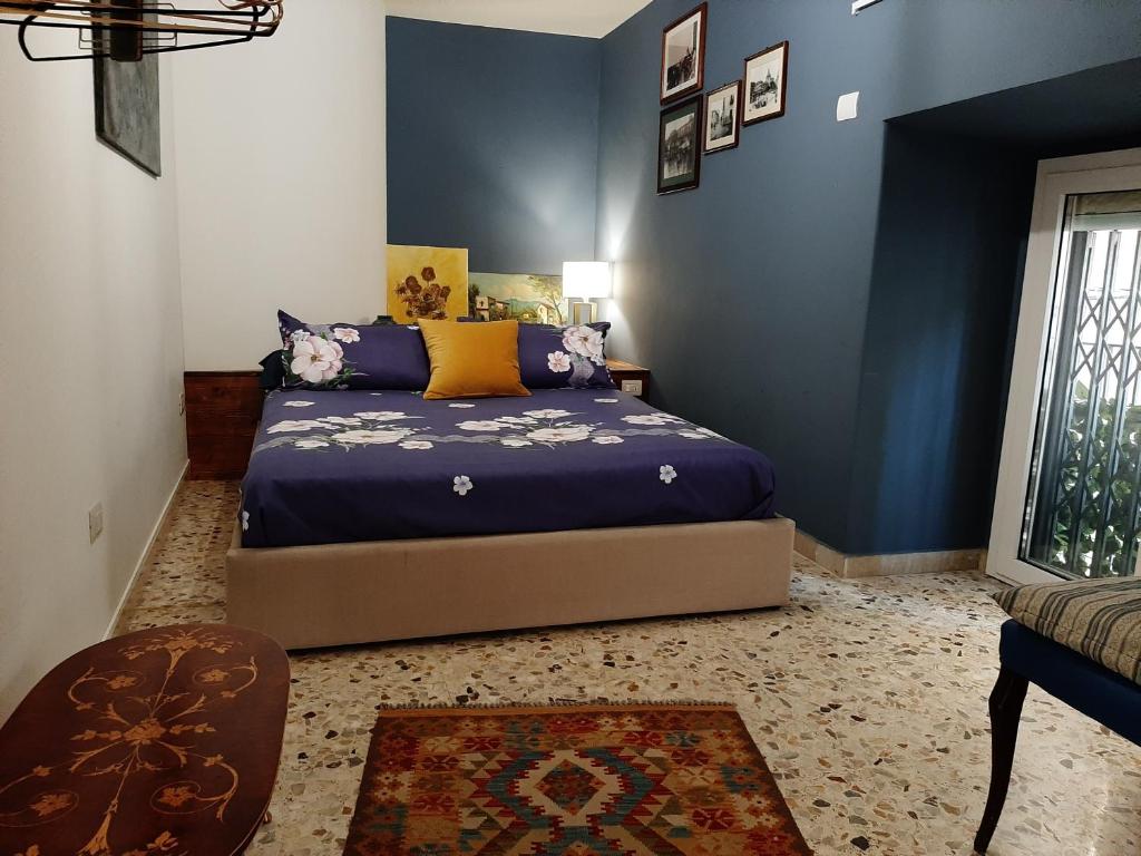 - une chambre avec un lit et un mur bleu dans l'établissement Casa Famoso, à Catane