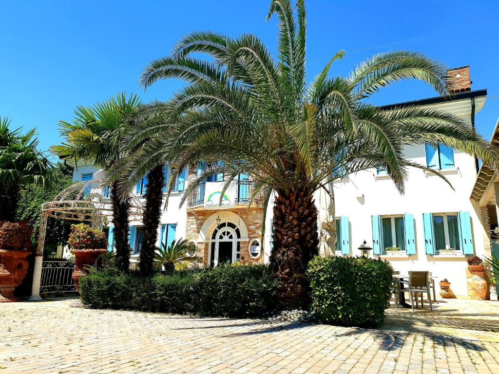 卡瓦利諾－特雷波爾蒂的住宿－多爾恰誇農莊酒店，一座建筑前的棕榈树