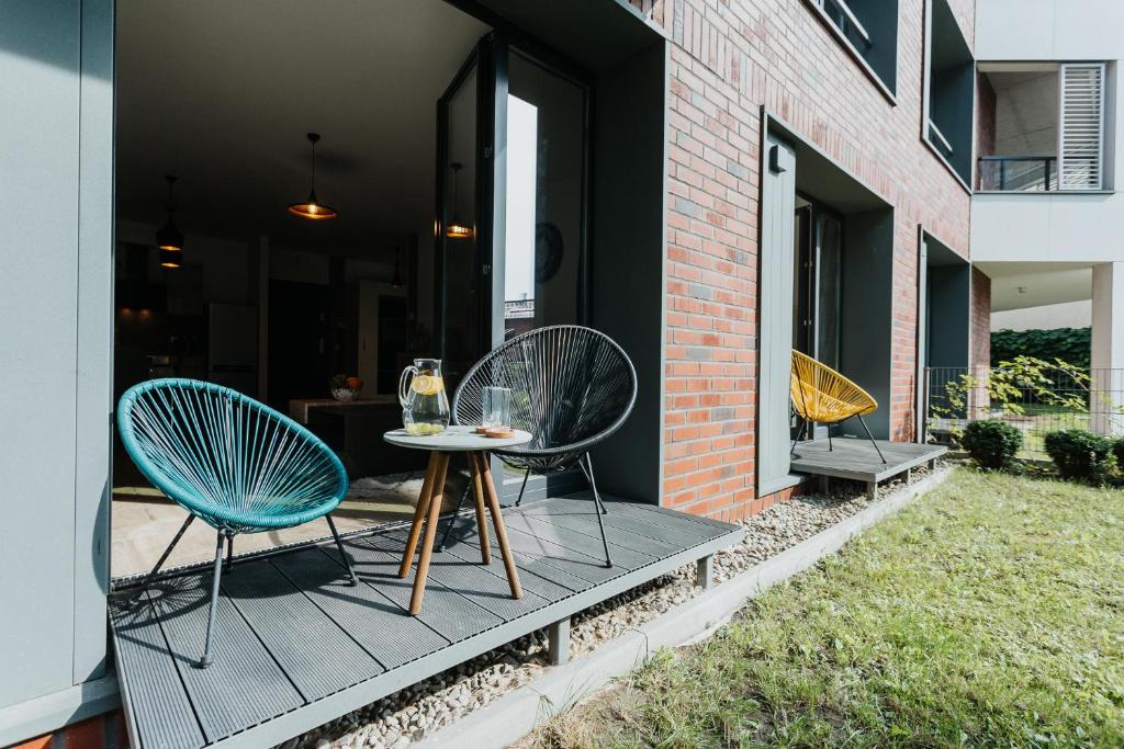 eine Terrasse mit 2 Stühlen und einem Tisch in der Unterkunft Garden - Quiet Apartment in the City Center in Krakau