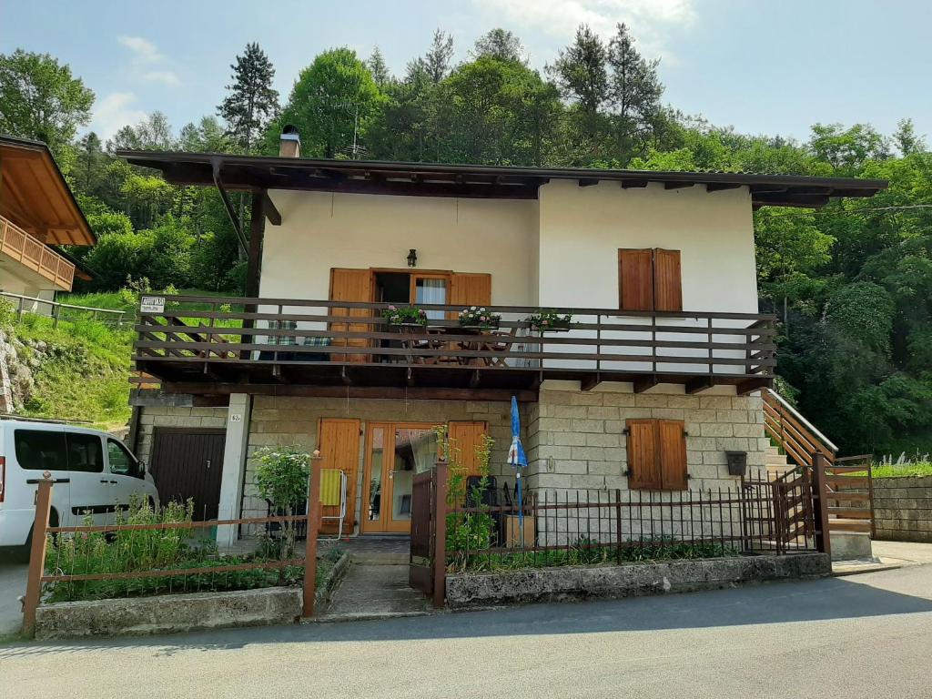 uma pequena casa com uma varanda em cima em Villetta Casale em Comano Terme