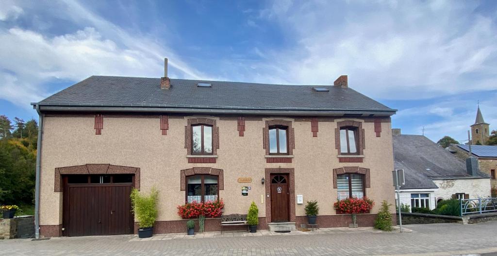 een groot bakstenen huis met een garage bij Au fil de l'eau in Grupont