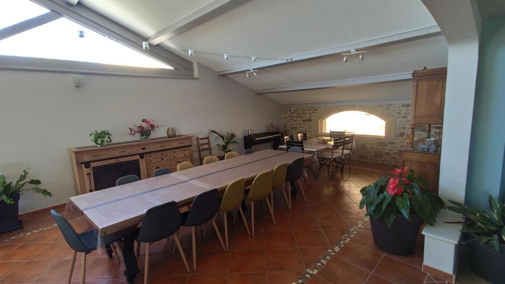 a large room with a long table and chairs at La Villa Moursoise 4 Etoiles in Mours-Saint-EusÃ¨be