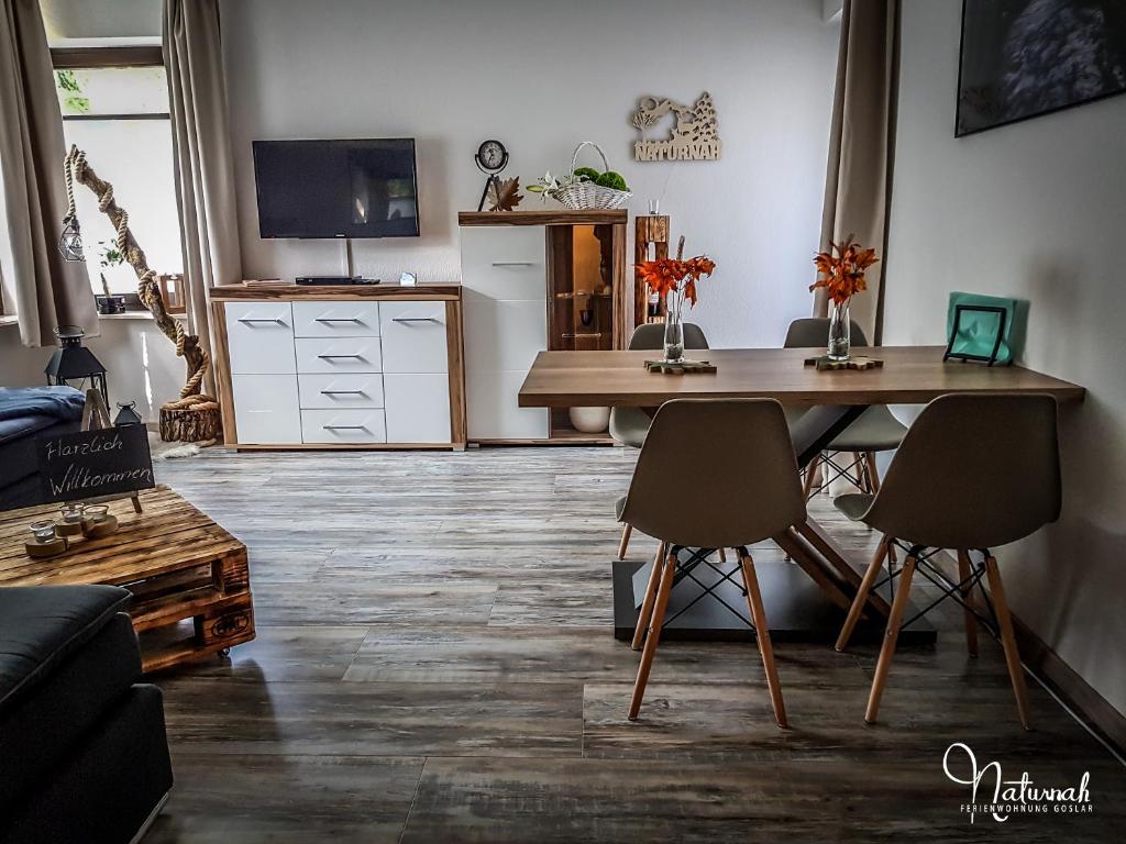 ein Wohnzimmer mit einem Holztisch und Stühlen in der Unterkunft Ferienwohnung Naturnah in Goslar