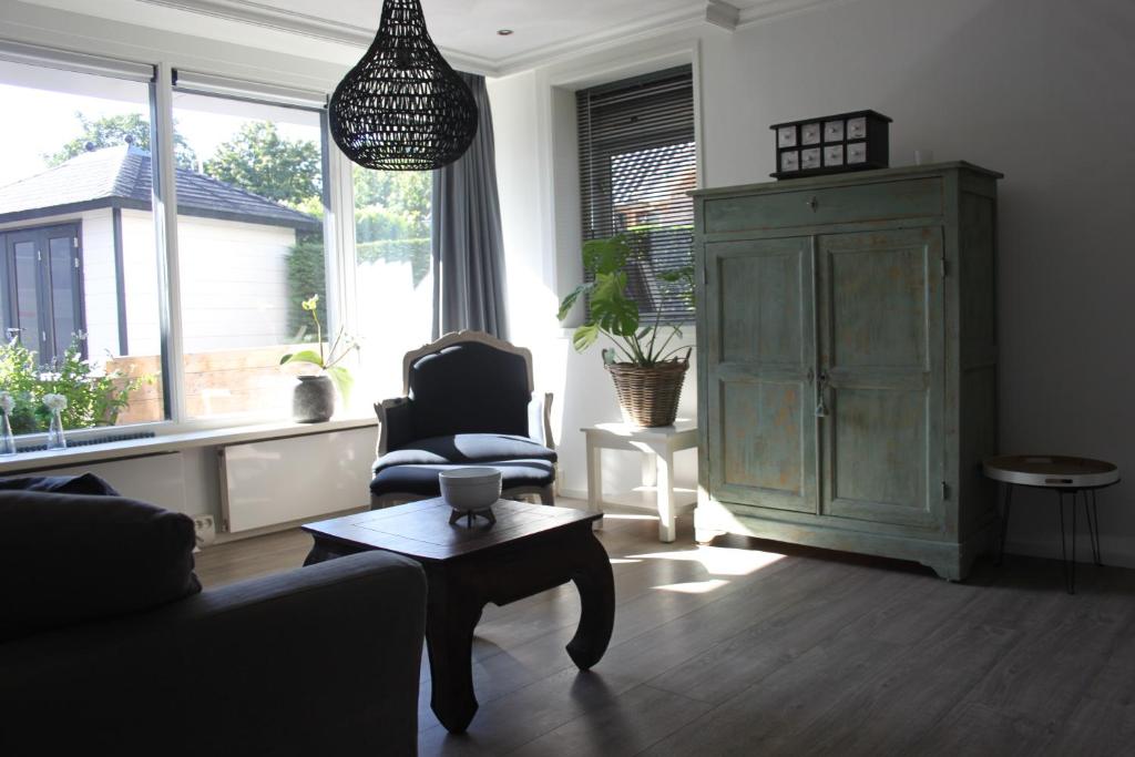 salon z kanapą, krzesłem i stołem w obiekcie Reseda apartment w mieście Alblasserdam