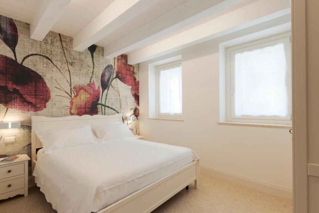 una camera con un letto bianco e un dipinto sul muro di Marinelli Apartments - La Madonnina a Osimo