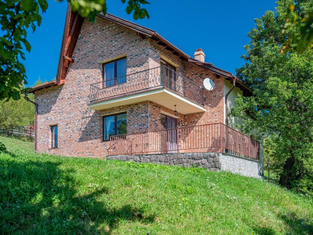 an old brick house with a balcony on a hill at Casa de Cărămidă in Moieciu de Jos