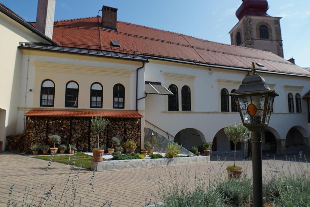 un antiguo edificio con una luz de la calle delante de él en Sobe Proštija en Ptuj