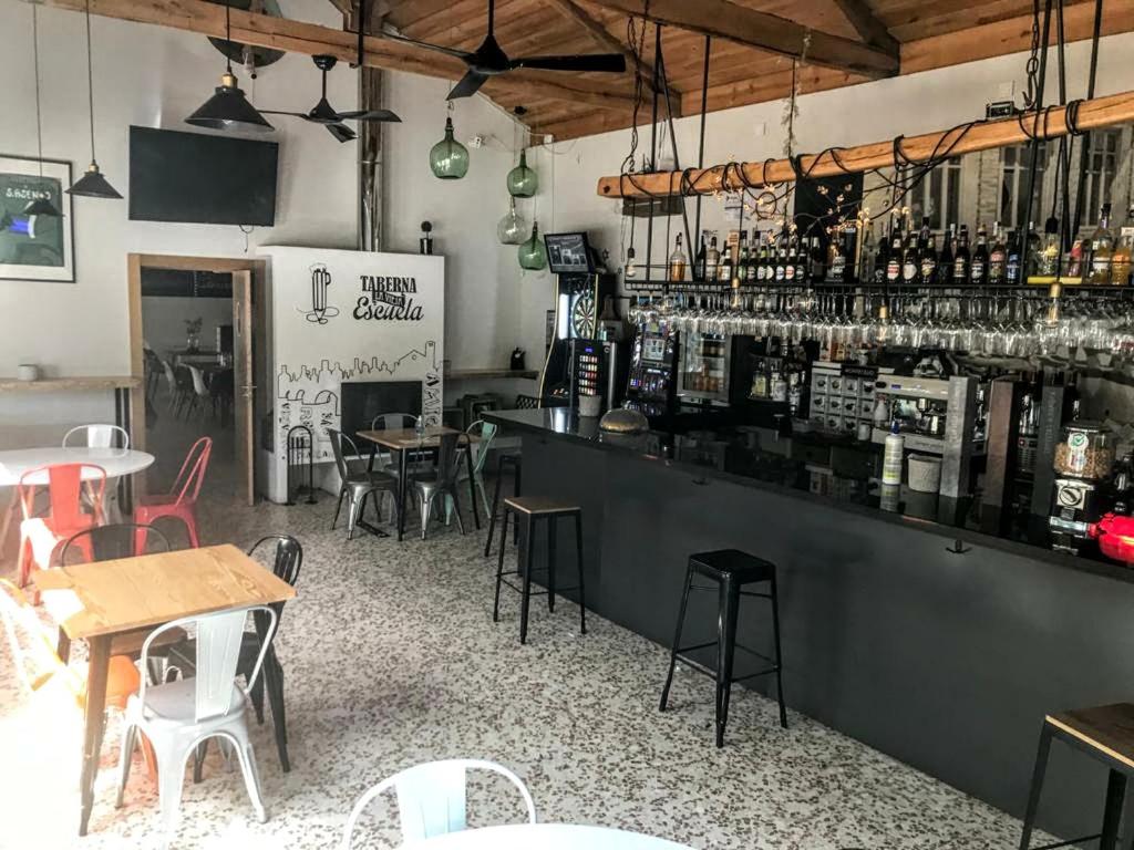 a restaurant with a bar with tables and chairs at La casa de Jesús Llandres in Husillos