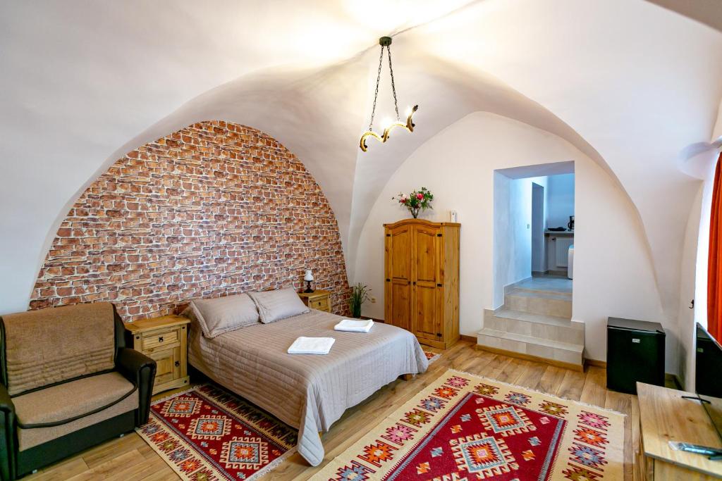 a bedroom with a bed and a brick wall at Rosenthal House in Sighişoara