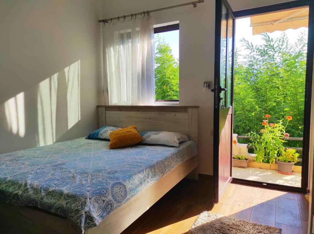 Schlafzimmer mit einem Bett, einem Fenster und einer Tür in der Unterkunft Apartments Four Countesses in Virpazar