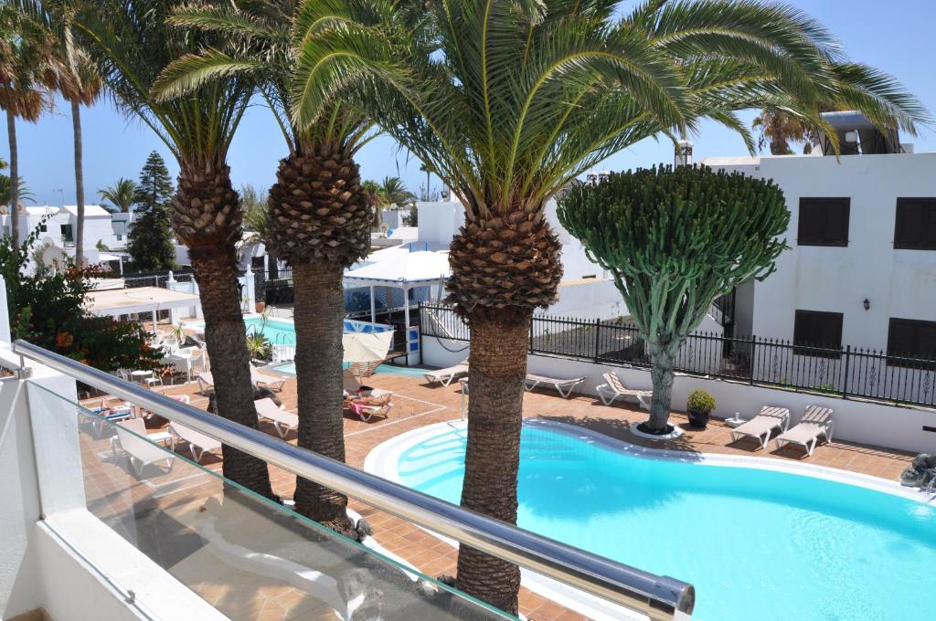 una vista dal balcone di un hotel con palme di Los Tulipanes a Puerto del Carmen