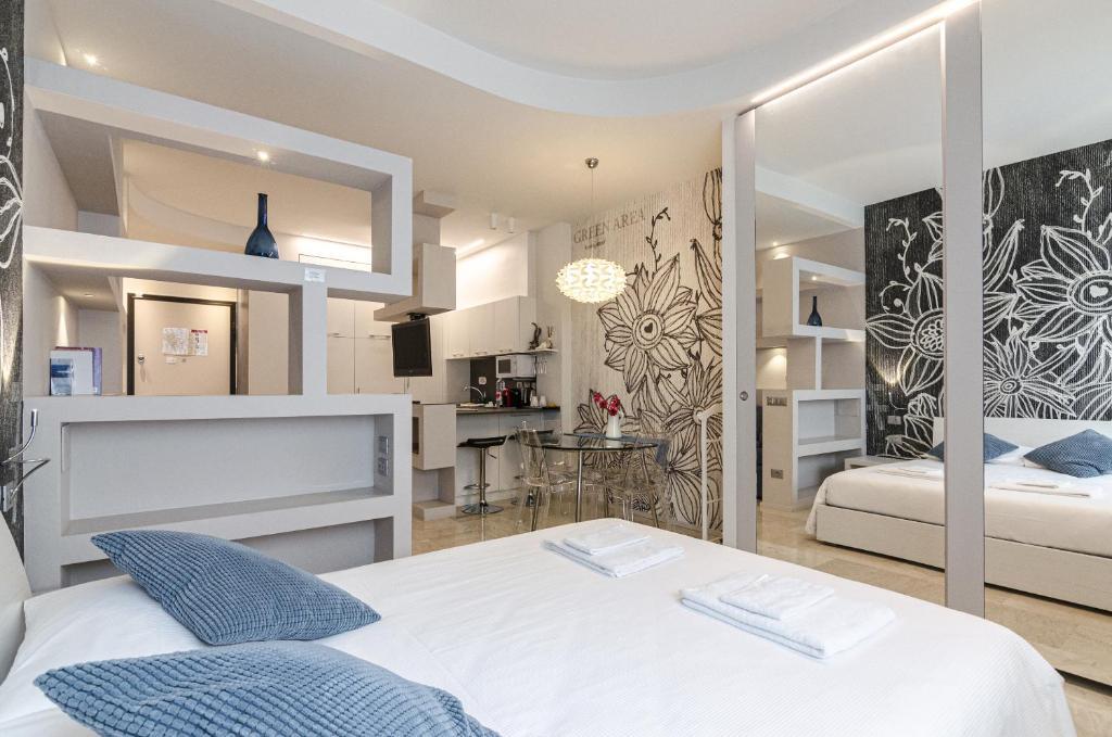 una camera con due letti e una cucina sullo sfondo di Residenza l'oasi a Bologna