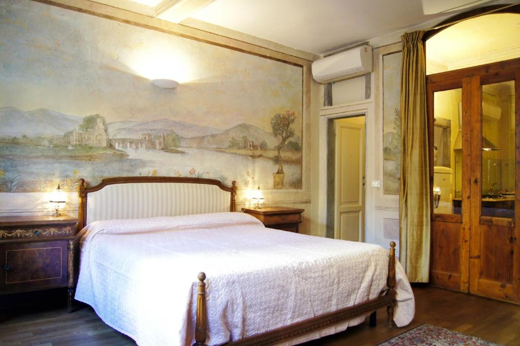 佛羅倫斯的住宿－梅拉藍曉公寓，卧室配有一张床,墙上挂有绘画作品