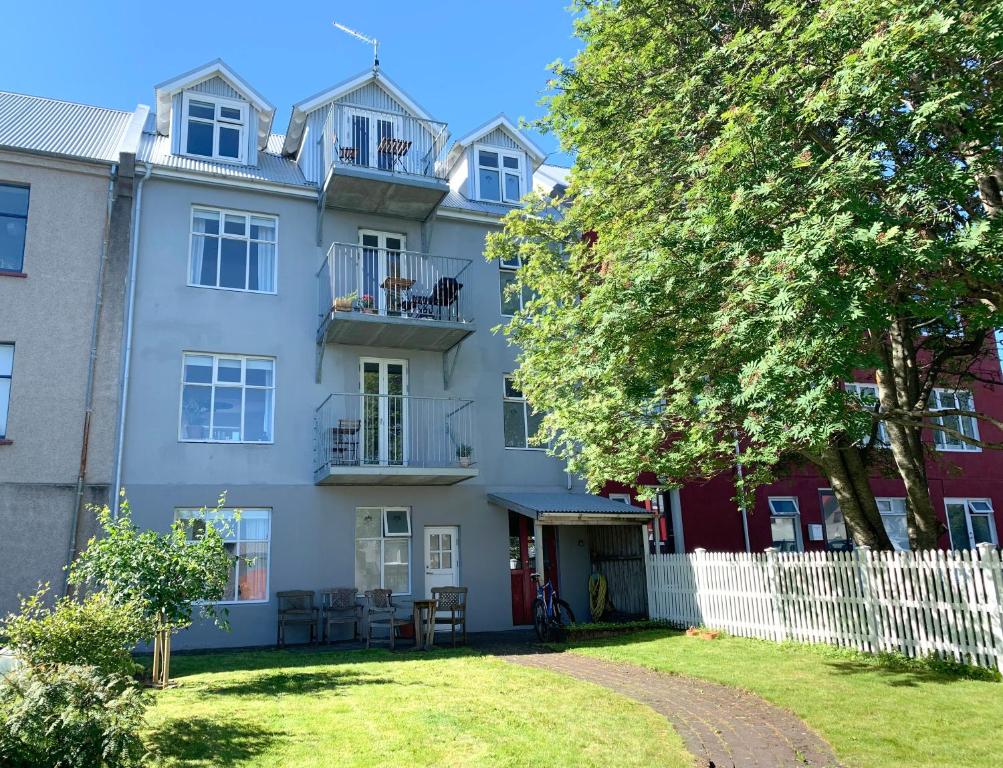 an apartment building with a white fence and a yard at Nest Apartments in Reykjavík