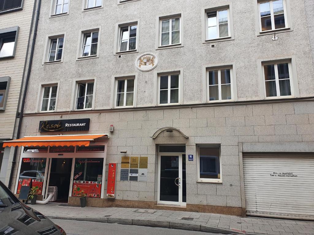 un gran edificio de ladrillo con una tienda en una calle en New City Center Stays 2, en Múnich
