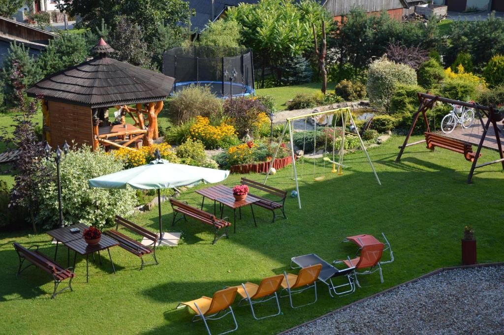 un giardino con tavolo, sedie e parco giochi di amel orawa a Podwilk