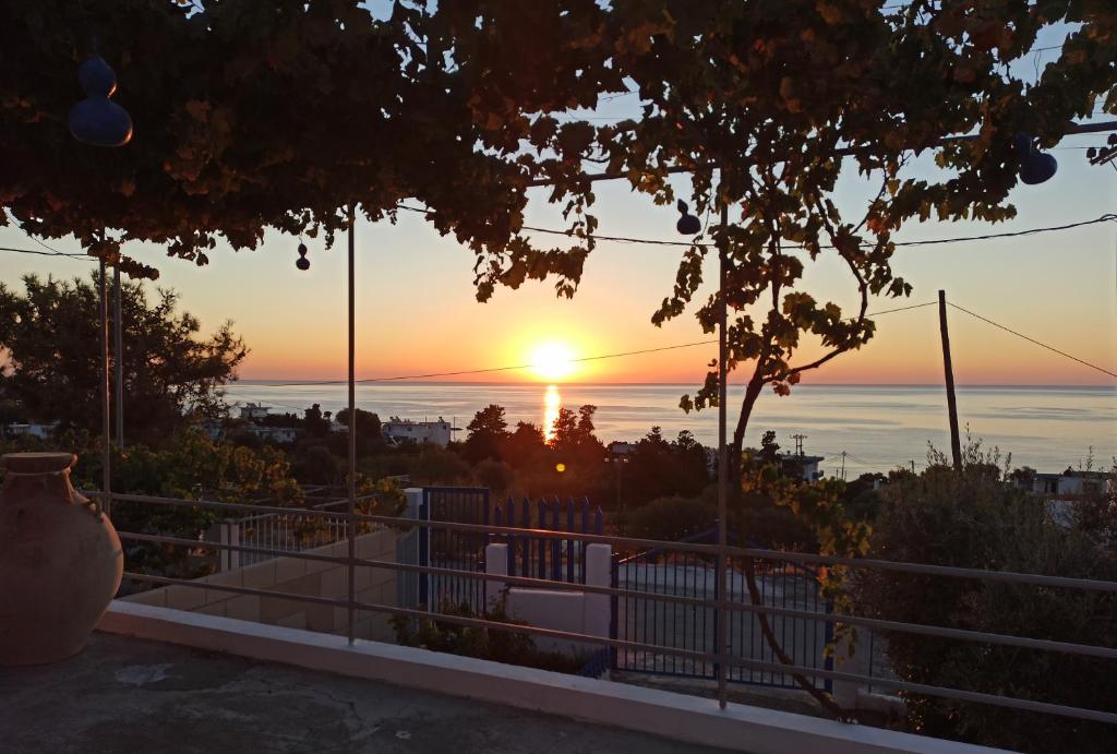 a sunset over the ocean from a house at Endless Blue Stegna in Archangelos