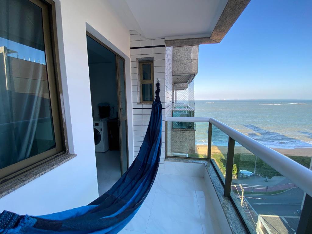 uma rede na varanda de uma casa com vista para o oceano em Relax frente mar em Vila Velha