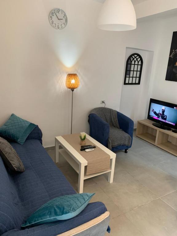 a living room with a couch and a table and a tv at PREMIUM COMFORT PRIVATE in Beer Sheva