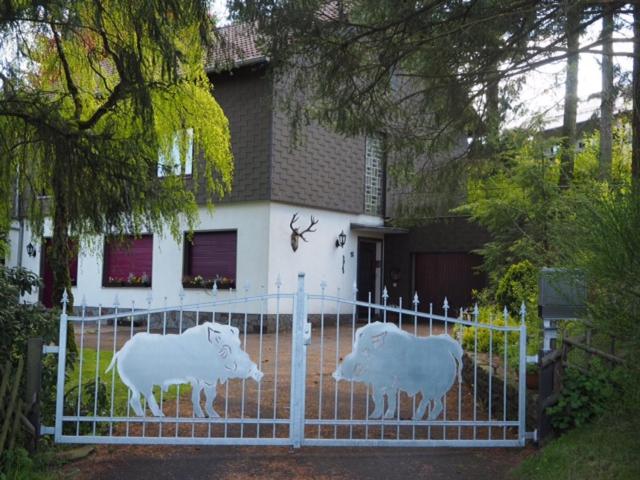 dos estatuas de vacas en una valla delante de una casa en Ferienhaus-stadtkyll-eifel Beim Förster mit zwei Schlafzimmern, en Stadtkyll