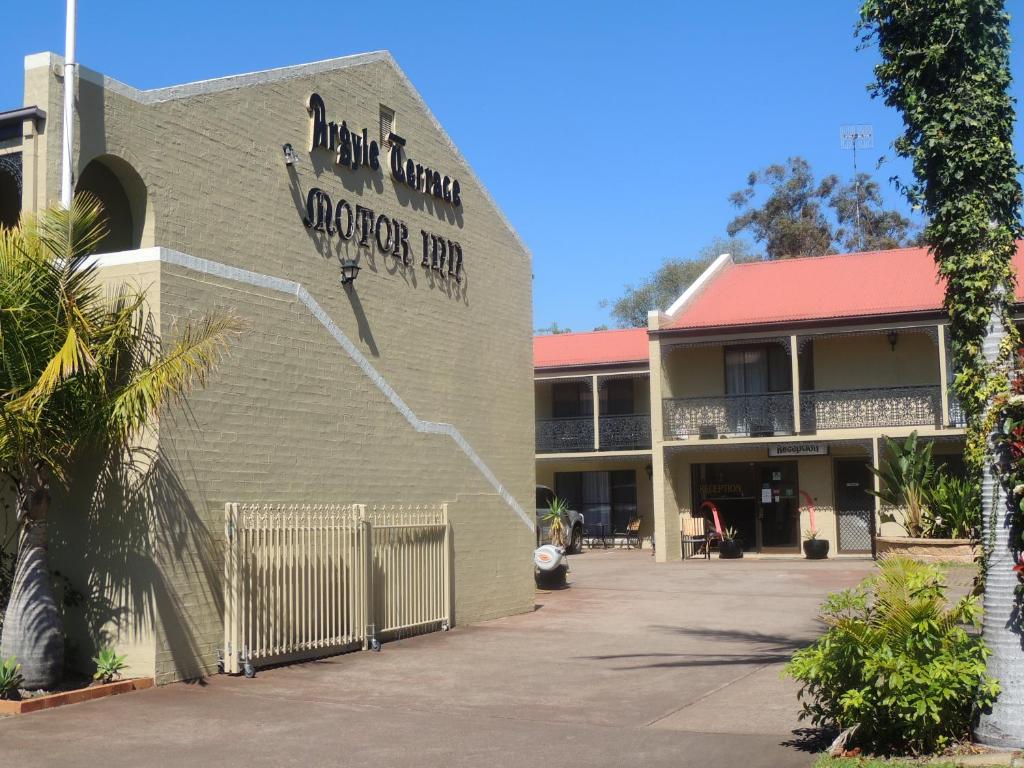 Un edificio con un cartello che legge la corsa dei coyote di Argyle Terrace Motor Inn a Batemans Bay