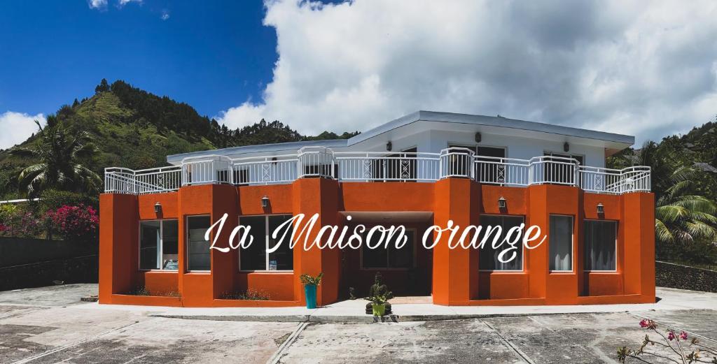 Un bâtiment orange avec un panneau. dans l'établissement La Maison Orange, à Moorea