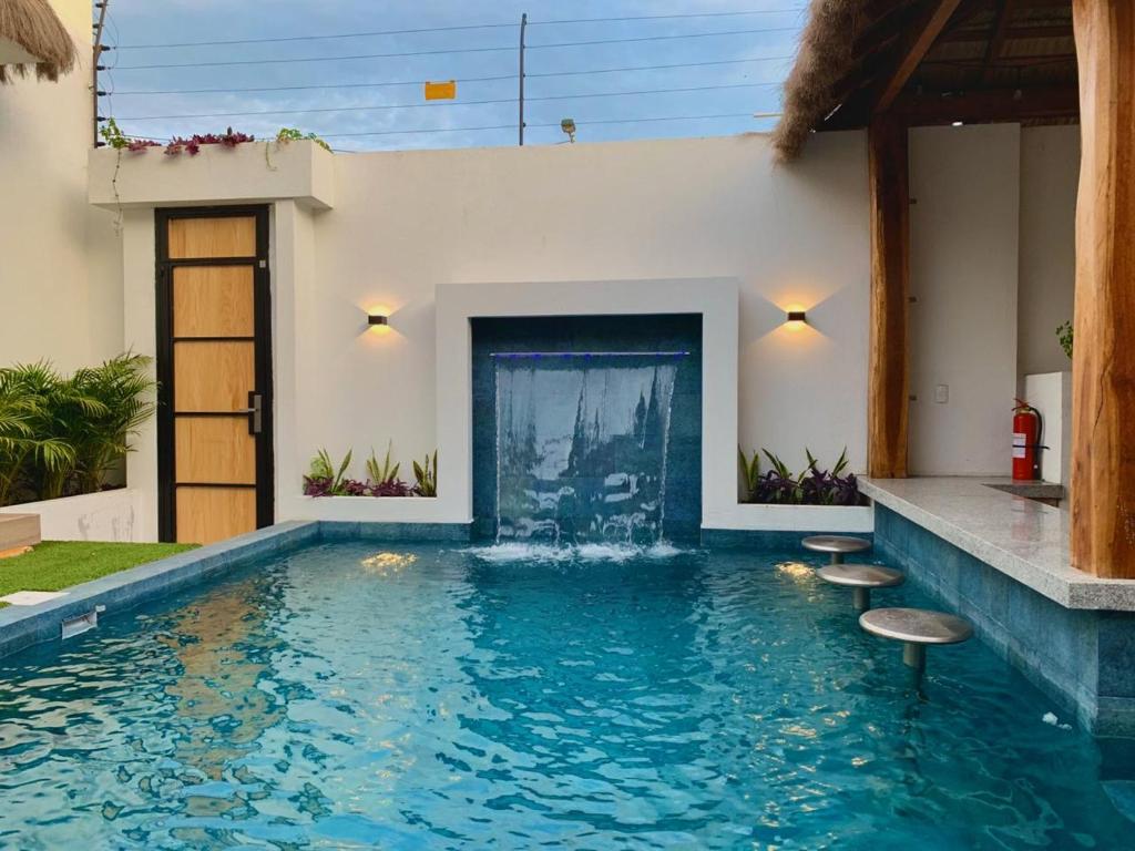 uma piscina com bancos em frente a uma casa em Villa Gloria em Salinas