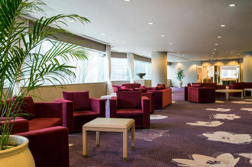 a waiting room with red chairs and a table at ANA Crowne Plaza Kanazawa by IHG in Kanazawa