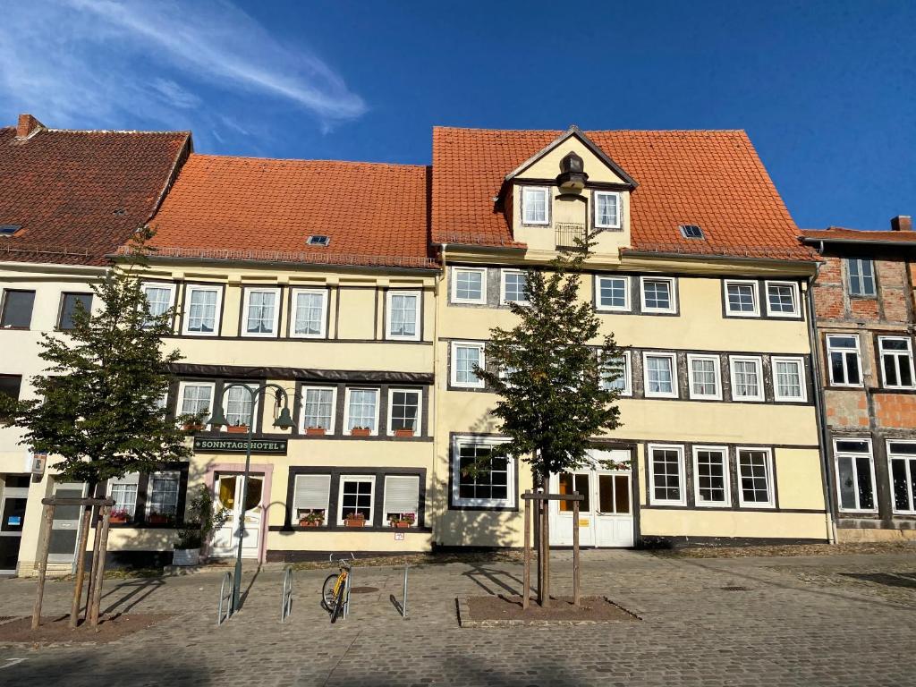 ein großes Gebäude mit einem Uhrturm davor in der Unterkunft Sonntags Hotel in Helmstedt